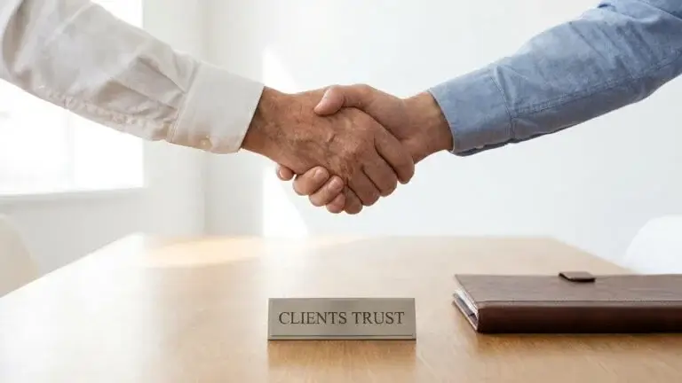 Two business professionals shaking hands over a desk with a Clients Trust sign, representing a reliable and trusted WordPress website design partner.