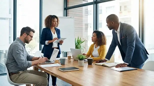 A diverse team of professionals collaborating in a modern meeting room, representing small and medium businesses that use custom WordPress website design.